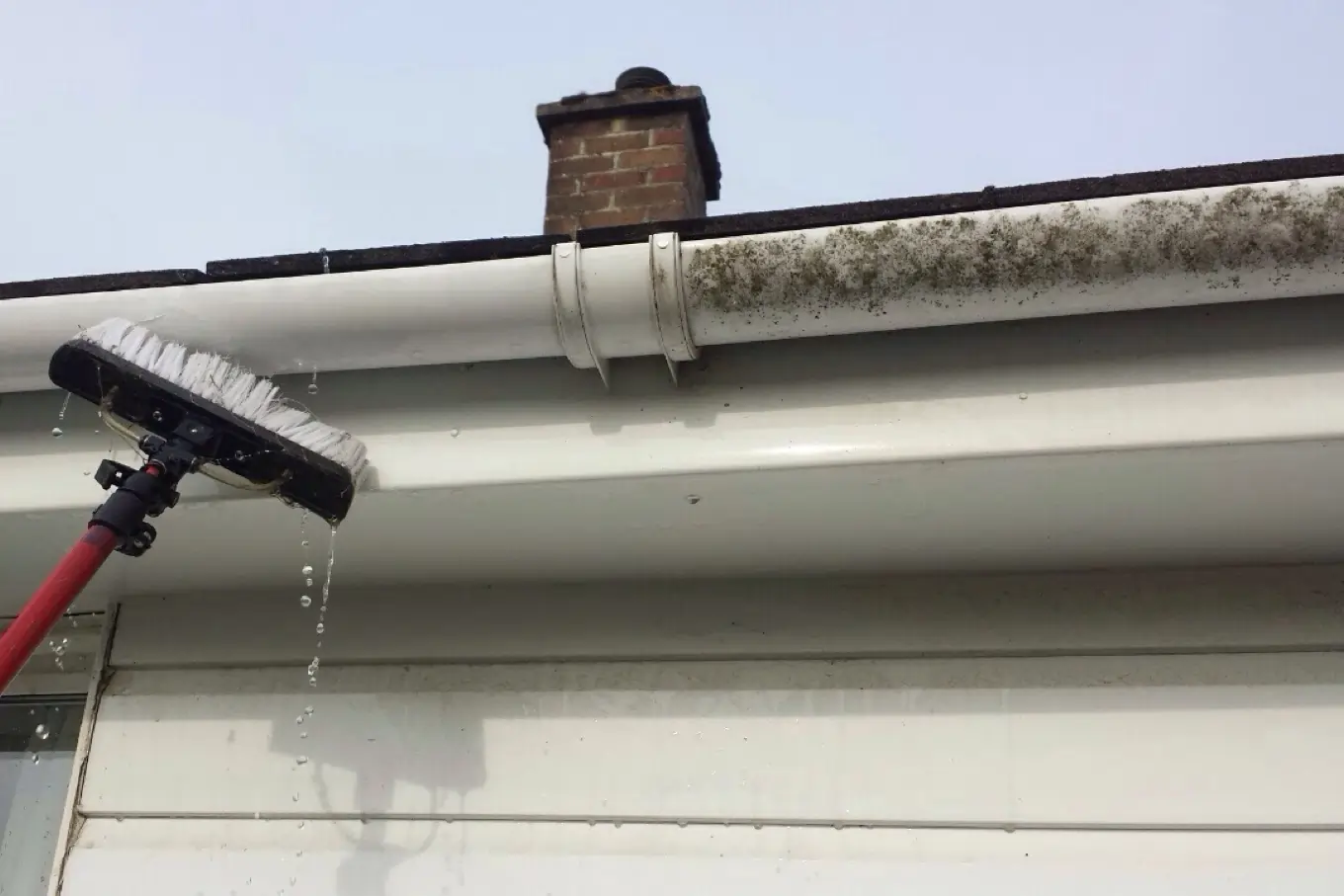 gutter cleaning on a white new build house